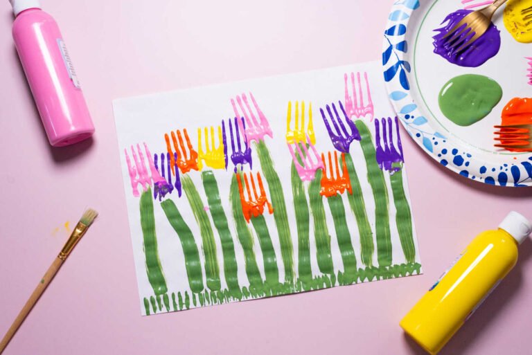 Painting green stems for fork-stamped tulips kids craft using a brush on white paper.