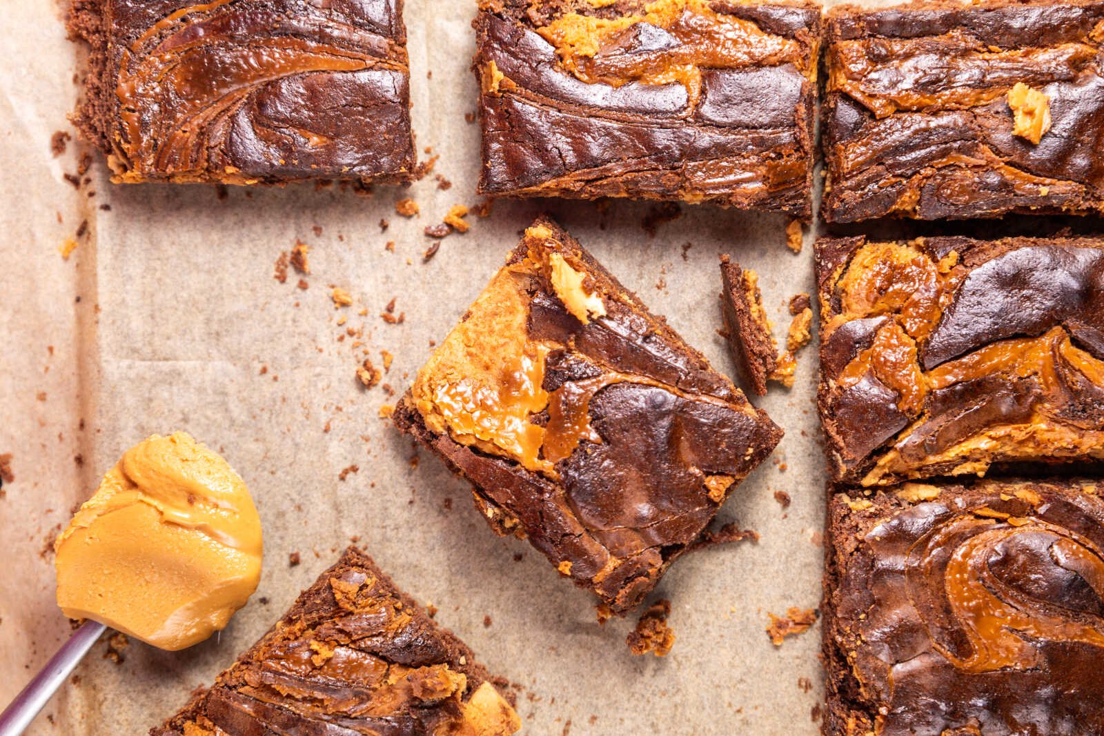 Peanut butter brownies squares with glossy chocolate tops and creamy peanut butter swirls.